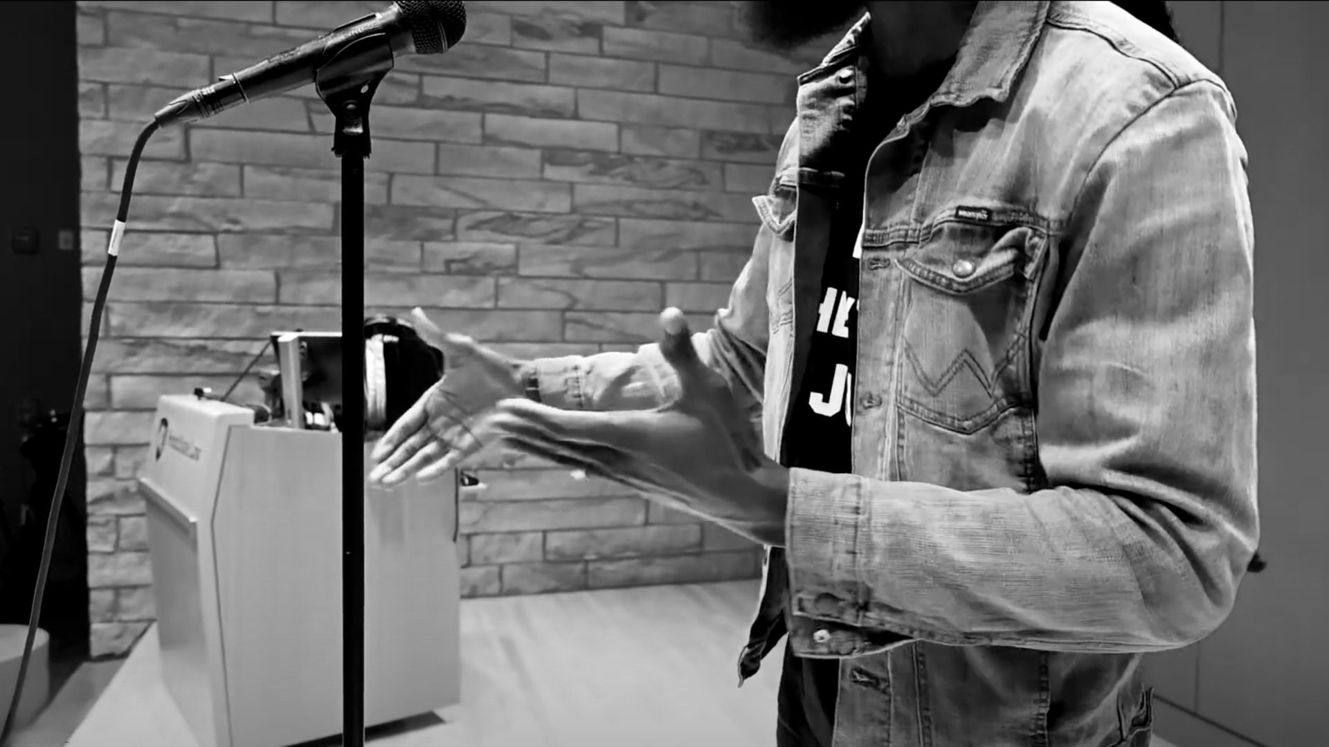 Dr. Wilson Okello's hands gesturing during spoken poetry presentation.